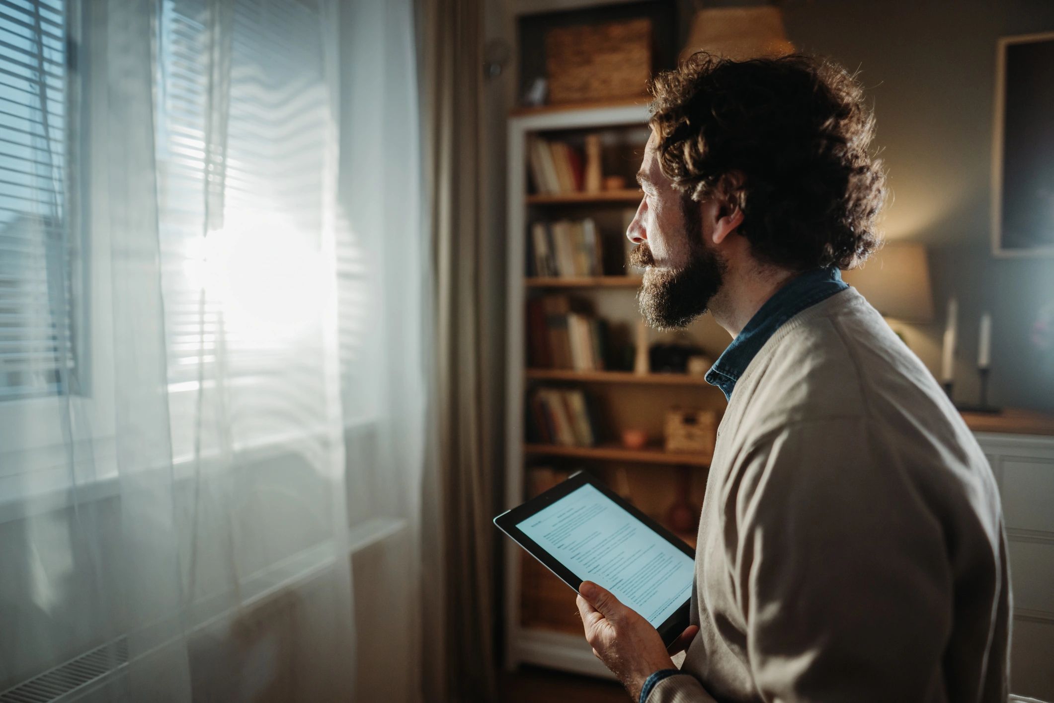 Person reading on a tablet with morning light